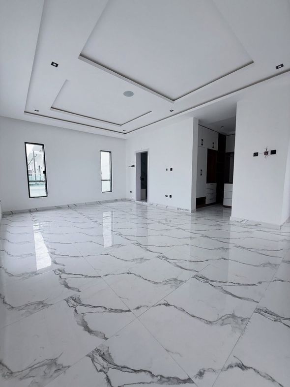 Bright empty modern room with white marble floor, recessed ceiling, and tall windows