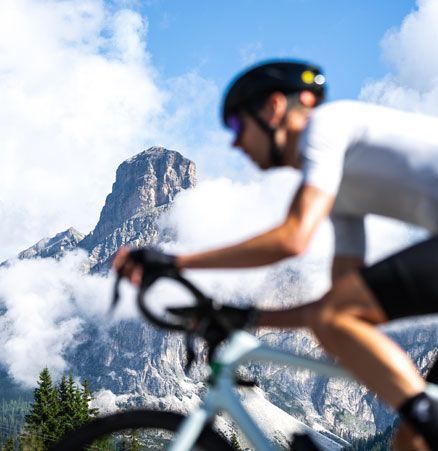 Een man met een helm fietst in de bergen.