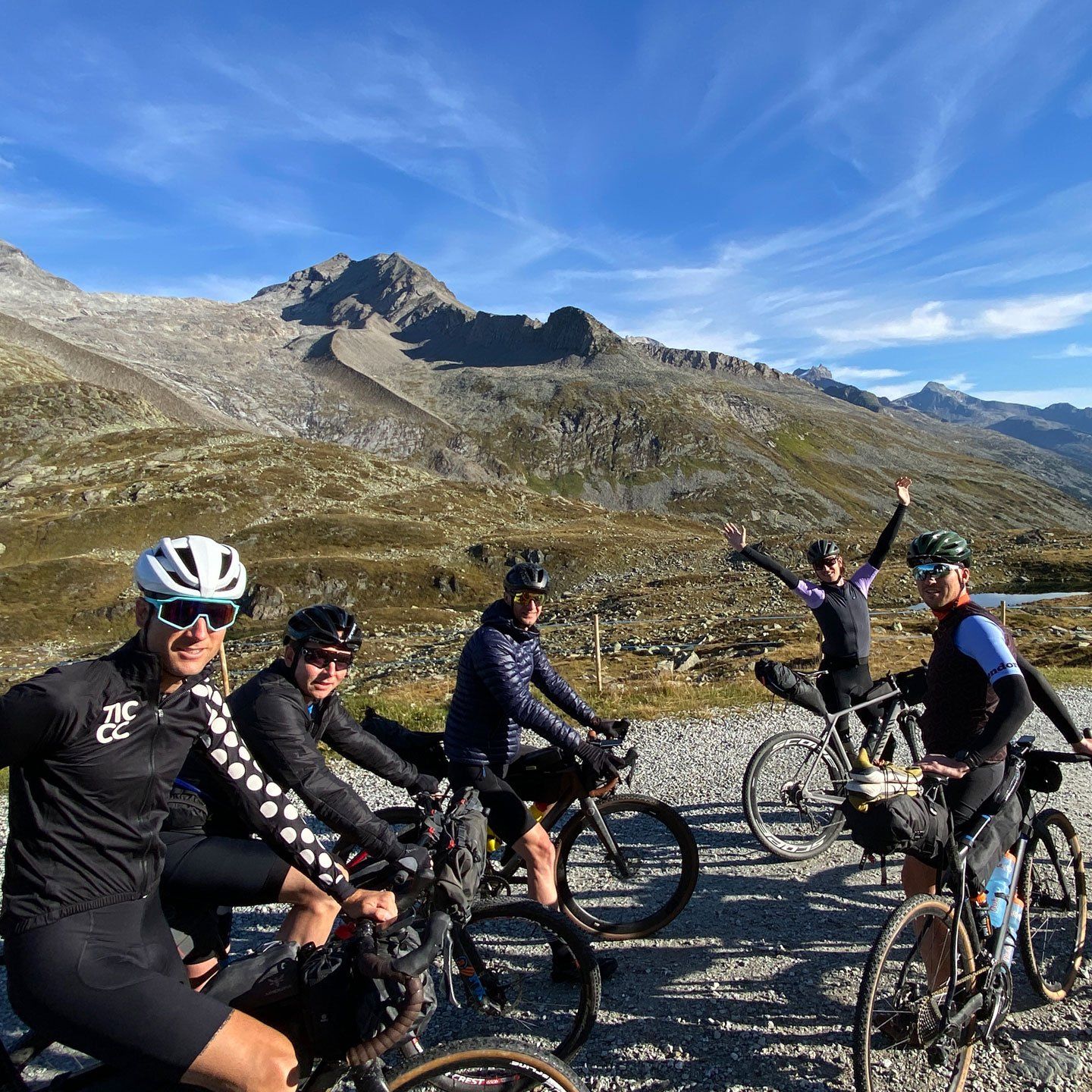 Een groep fietsers poseert voor een foto met een berg op de achtergrond
