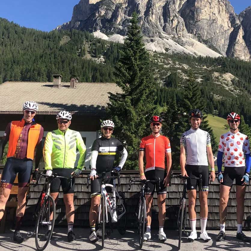 Een groep fietsers poseert voor een foto voor een berg