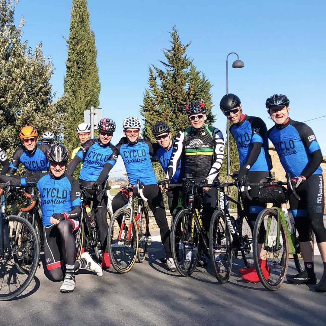 Een groep fietsers poseert met hun fiets voor een foto