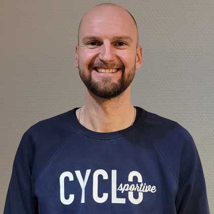 Een kale man met baard draagt ​​een blauw sweatshirt met het woord cyclus erop.