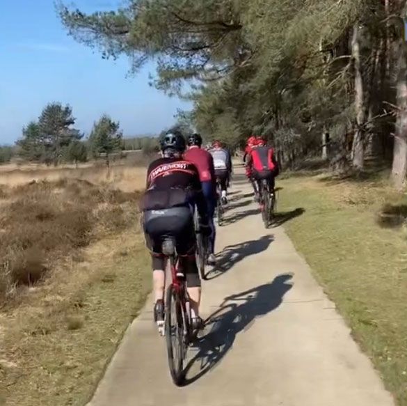 Een groep mensen fietst over een pad.