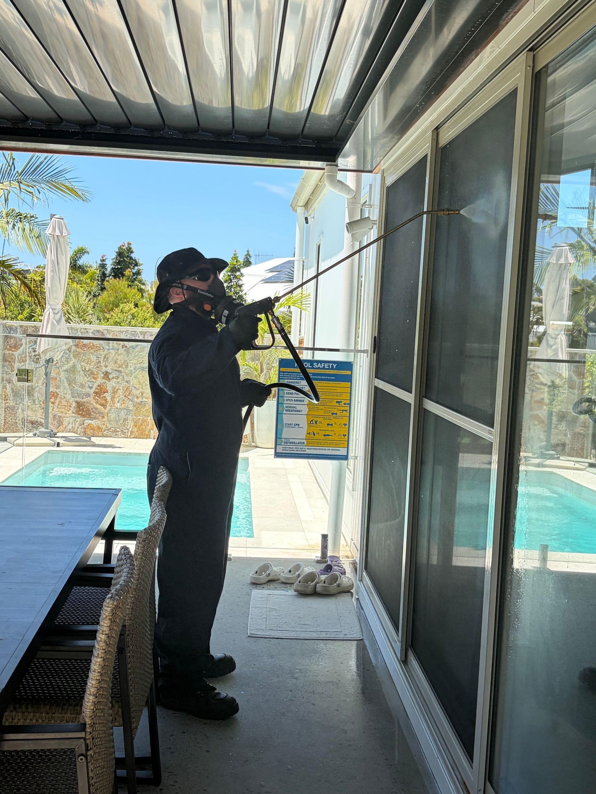 Person in Protective Suit Applying Sealant Near a Window Frame — FUMATEX In Lake Cathie, NSW