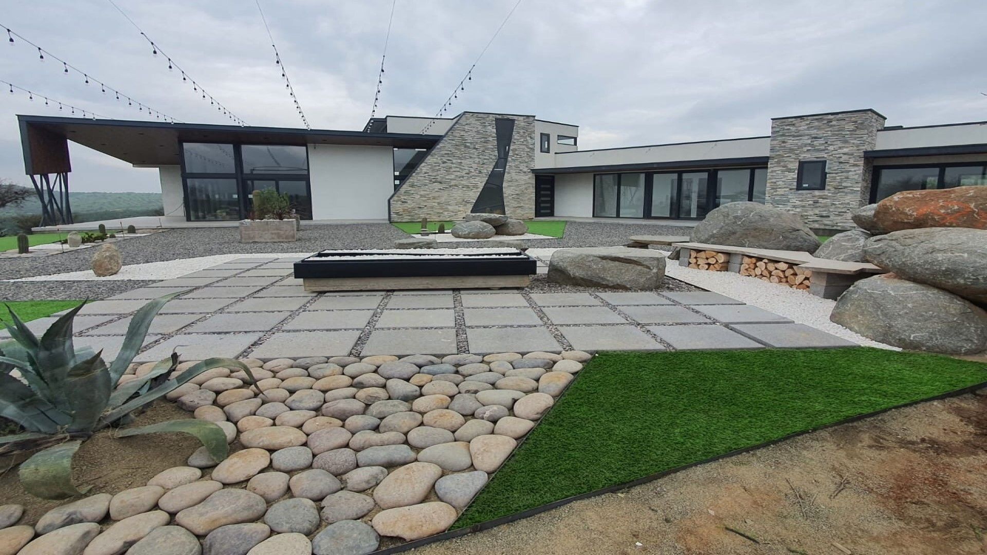 Una casa grande con muchas rocas delante de ella.