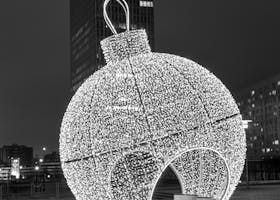 Grande sculpture lumineuse en forme d'ornement de Noël dans la ville la nuit.