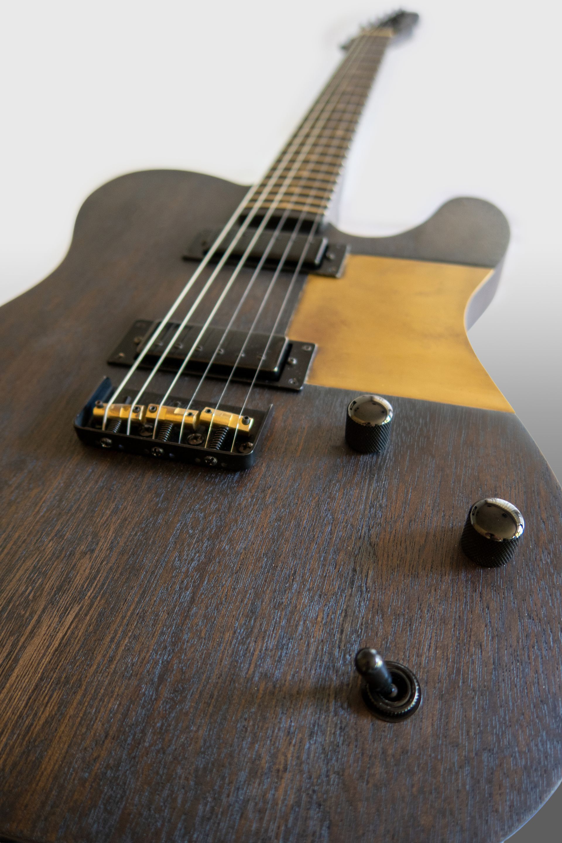 Een close-up van een bruine elektrische gitaar . Messing slagplaat Custom made guitar. Gitaar reparatie. Art of Noise Guitars