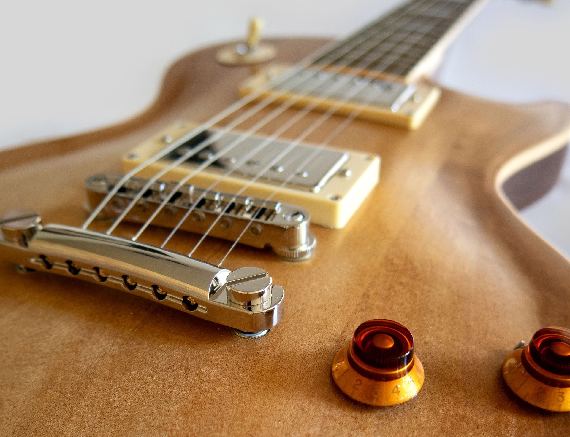 Een close-up van een gitaar met een brug en knoppen