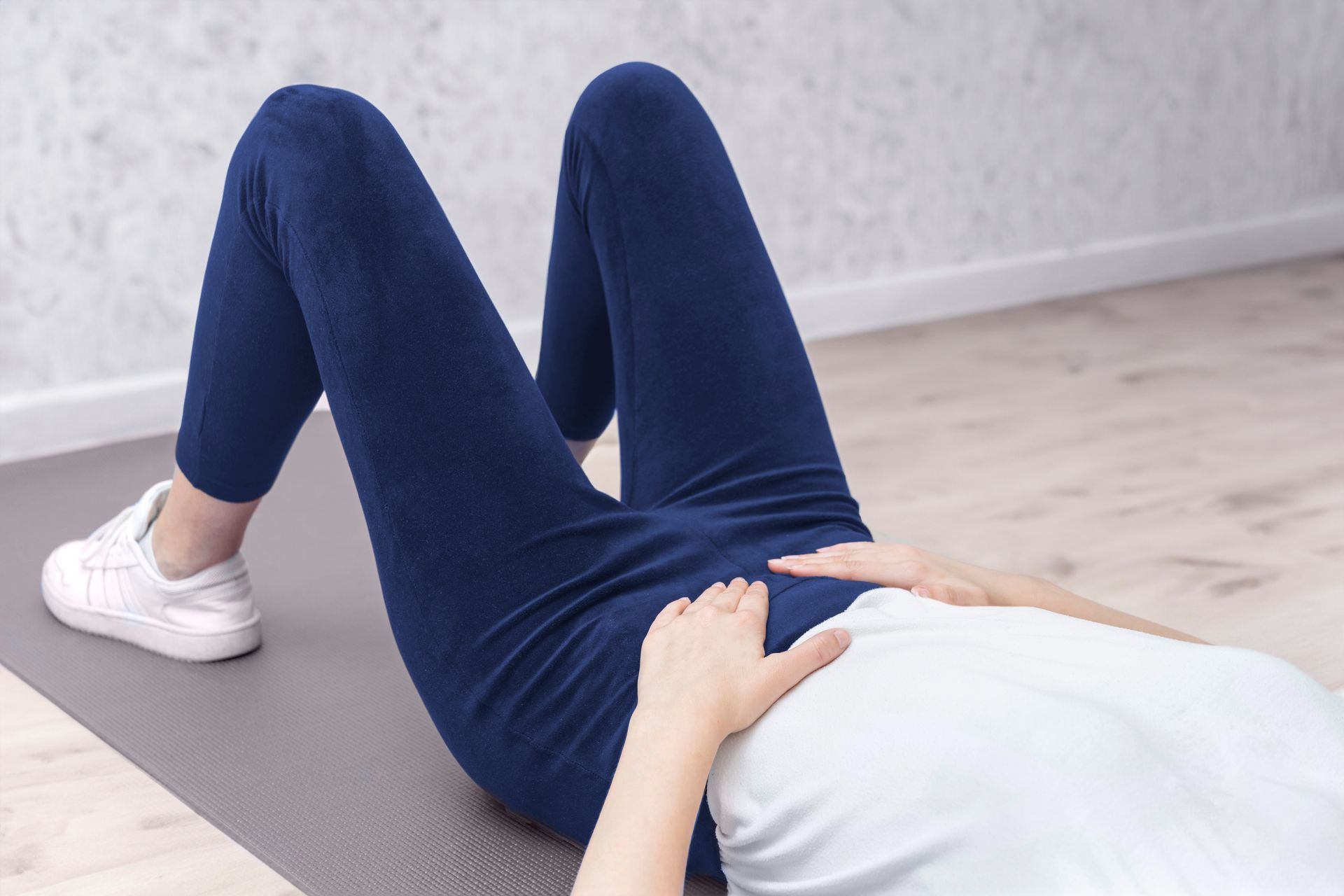 Eine Frau liegt auf dem Bauch auf einer Yogamatte.