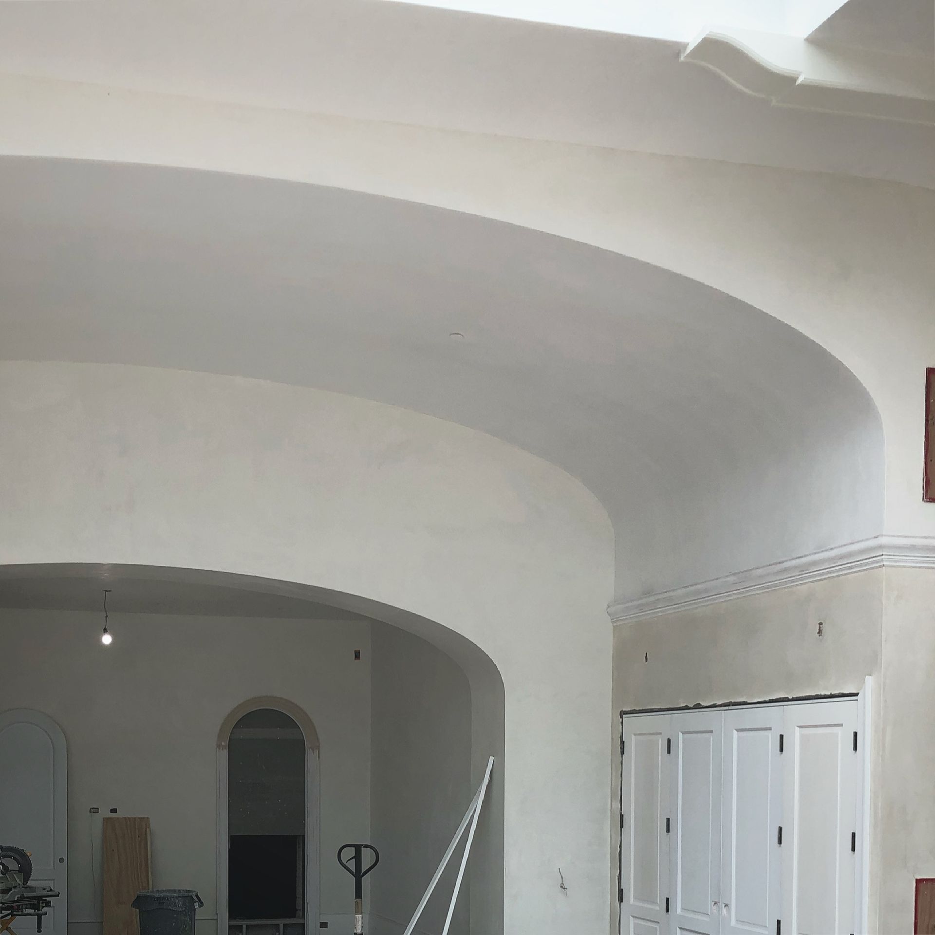 A room with arched ceilings and white cabinets