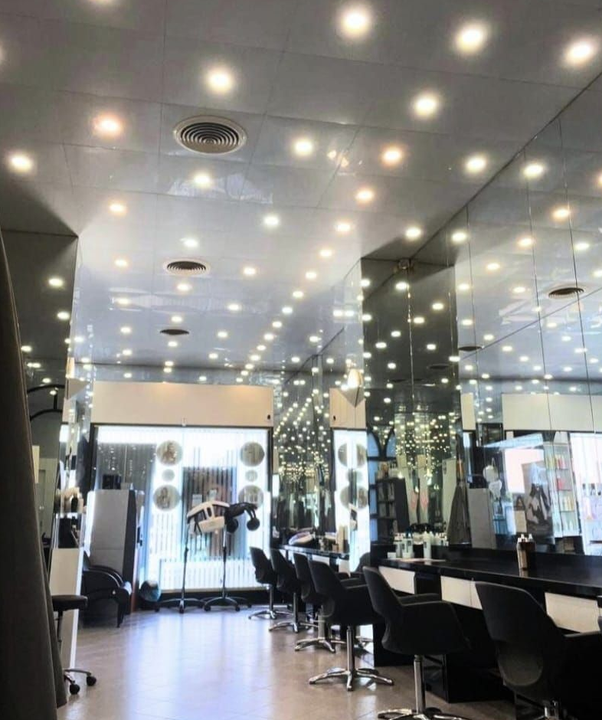 Gruppo di sette donne in camicia nera, sorridenti in un ambiente ben illuminato.