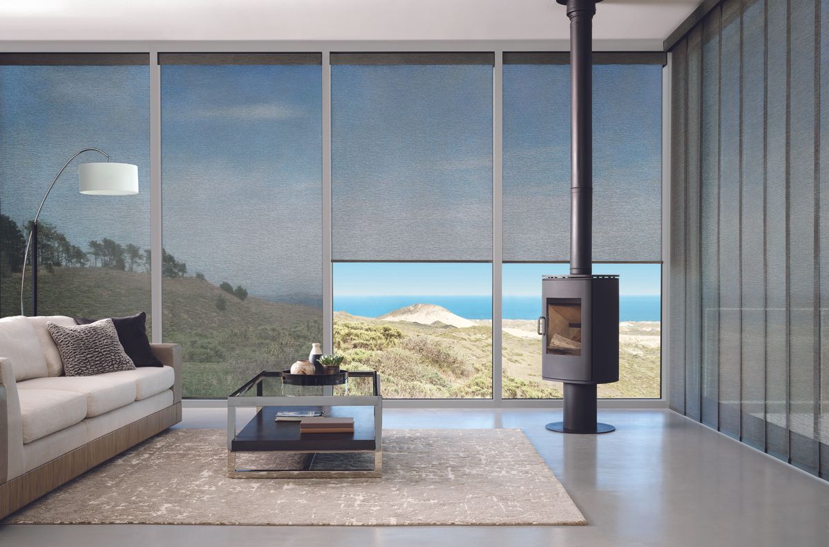 Living room with large windows, coastal view, couch, fireplace, modern design, neutral tones.