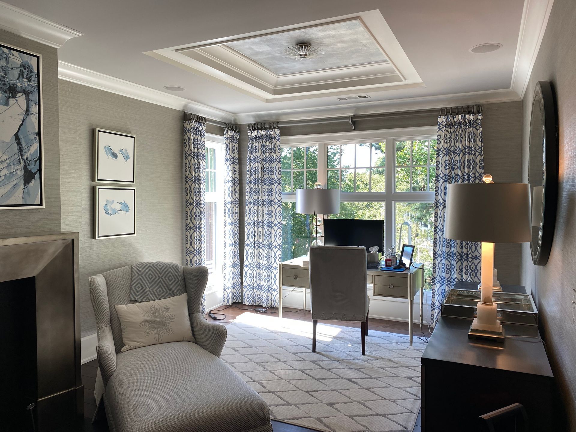 Office with chaise lounge, desk, patterned curtains, and a tray ceiling.