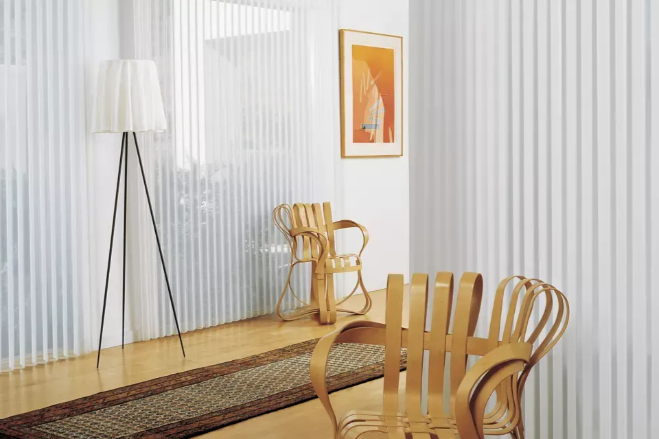 Room with striped wallpaper, wooden chairs, floor lamp, and a framed artwork.