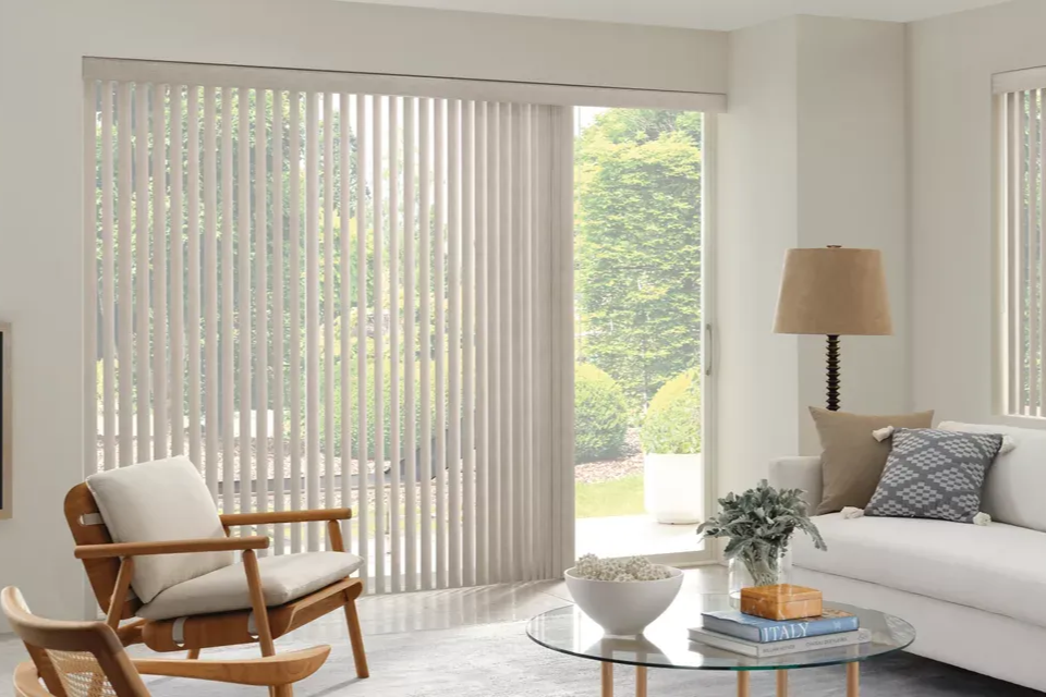 Living room with vertical blinds, a glass coffee table, and a white sofa.