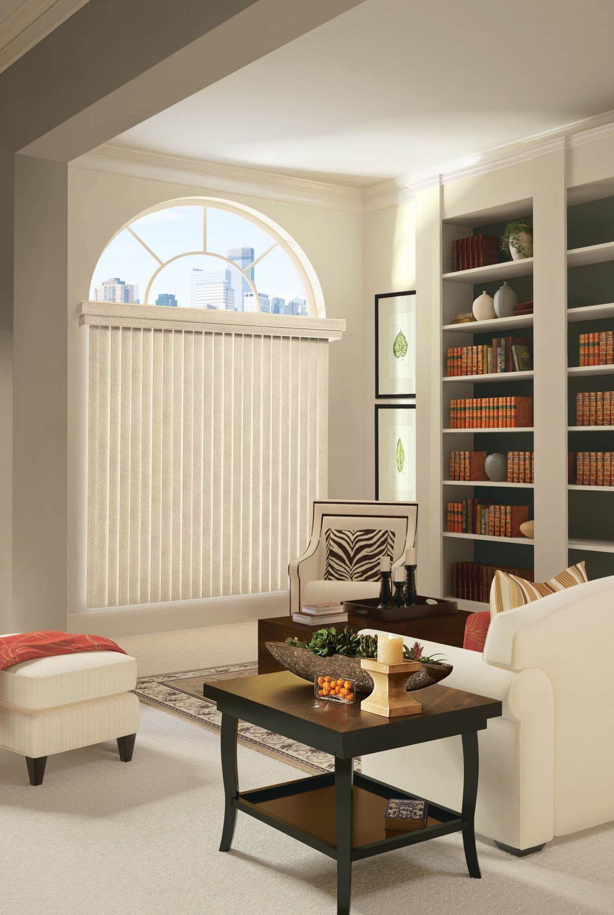 Living room with large arched window, vertical blinds, built-in bookshelves, and cream-colored furniture.