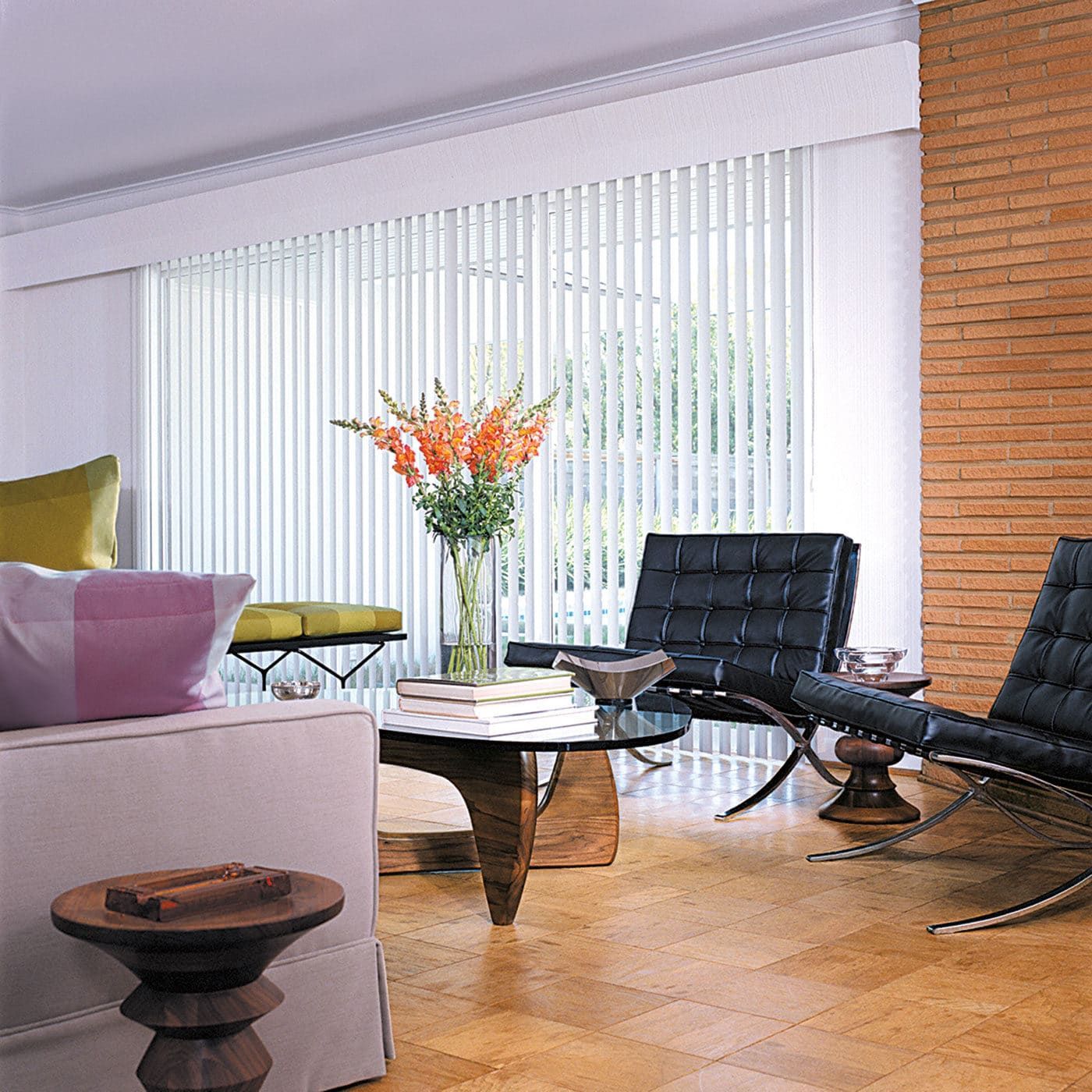 Living room with white vertical blinds, black chairs, a coffee table, and wood floors.