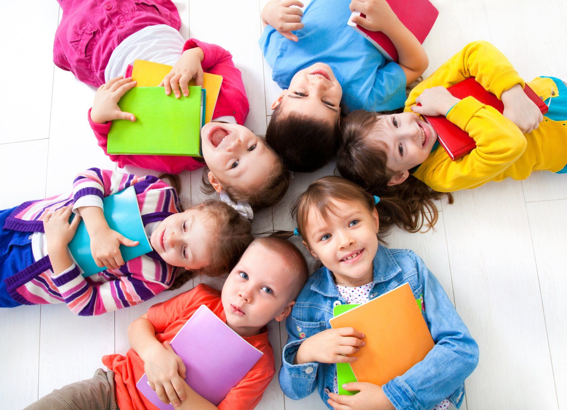 Childcare — Happy Children Holding School Materials in Edison, NJ