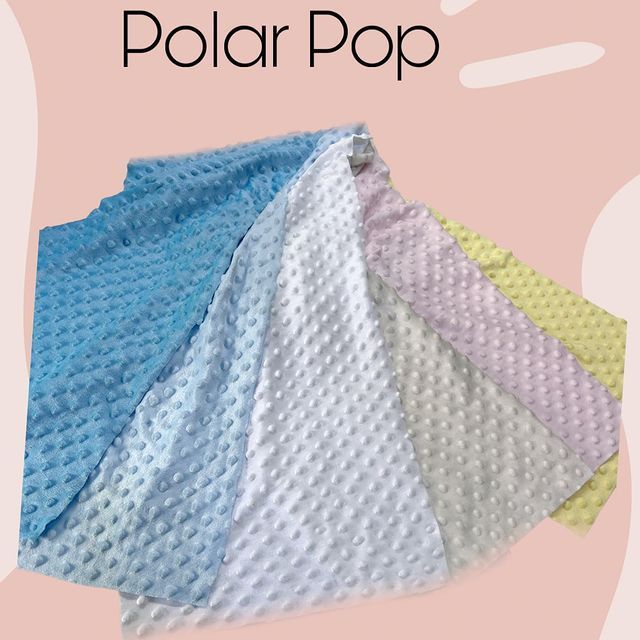 Una manta polar pop está apilada una encima de la otra