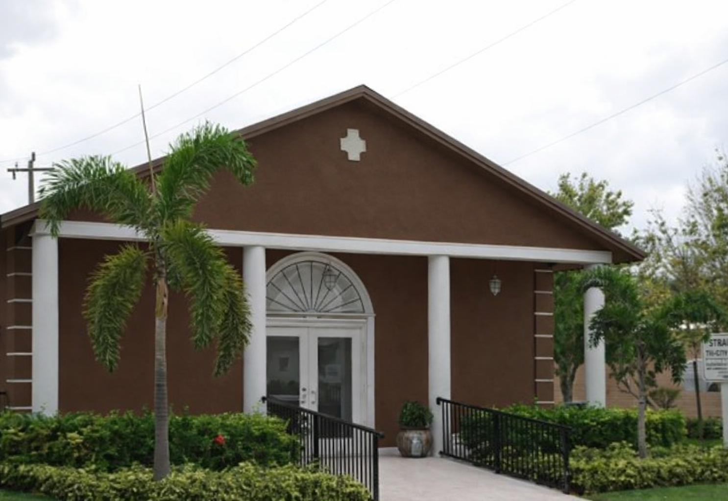 A large white building with a brown roof and a lot of windows.