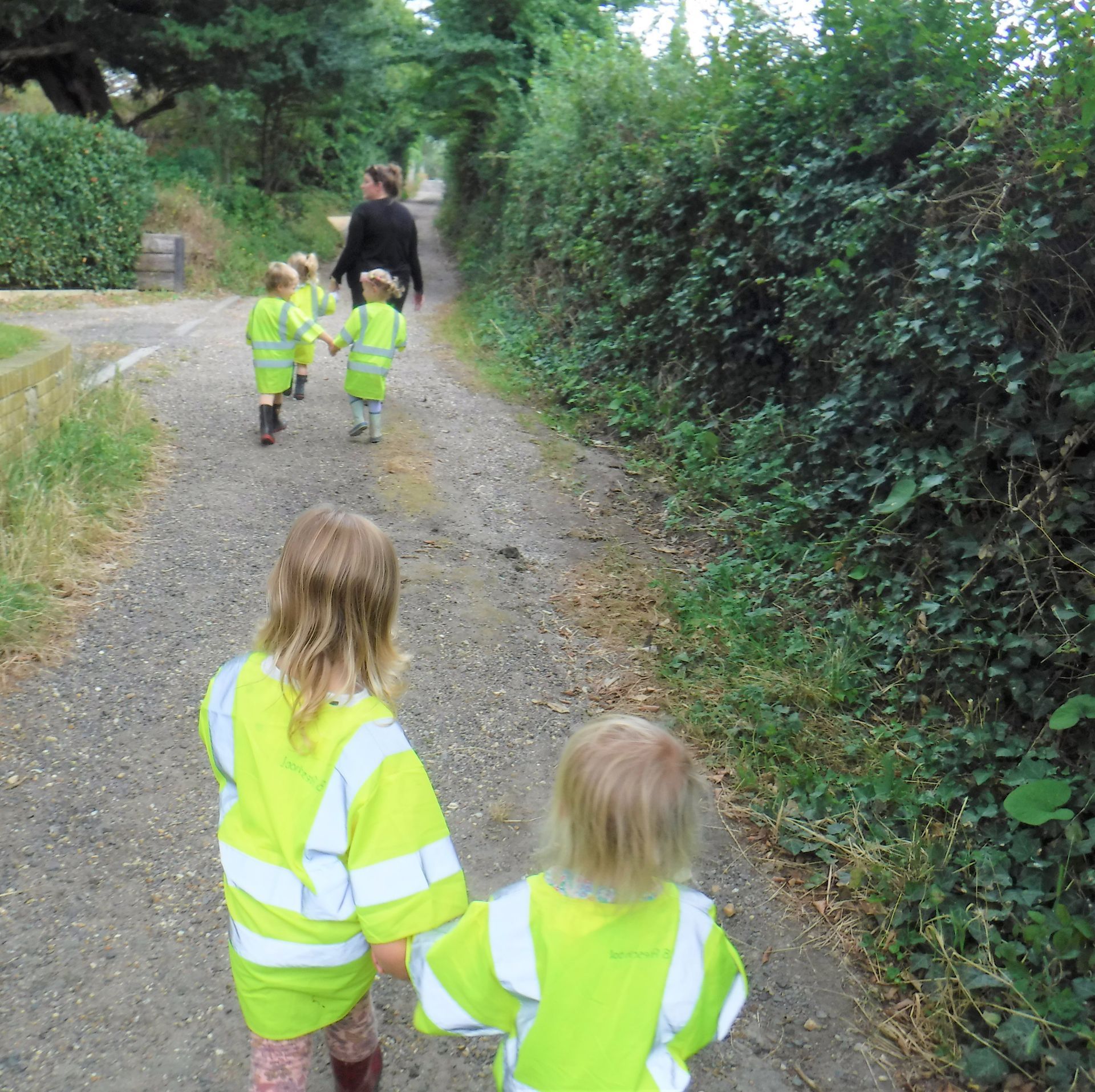 A group of children are walking down a dirt road