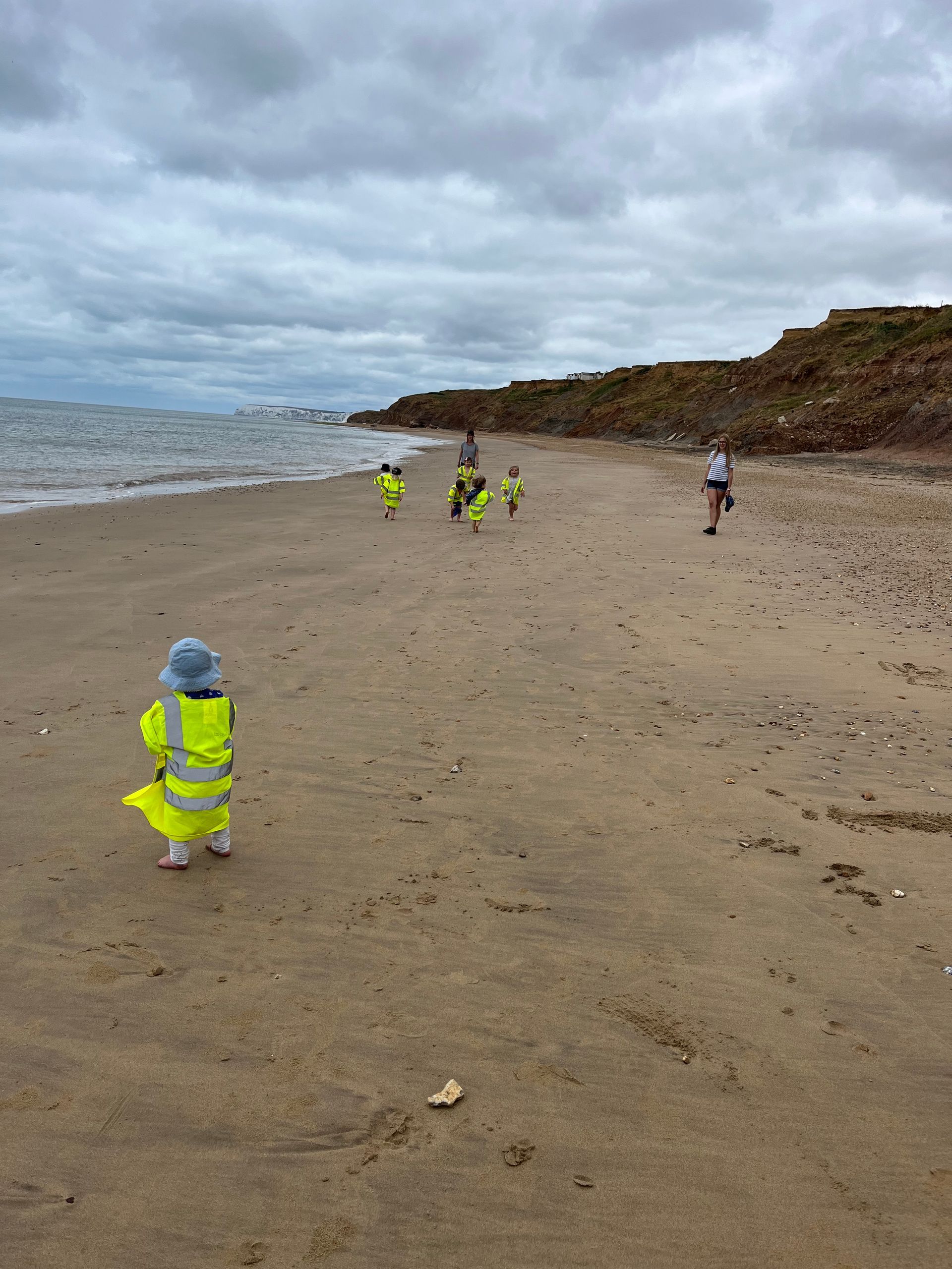 A group of people are walking on a sandy beach