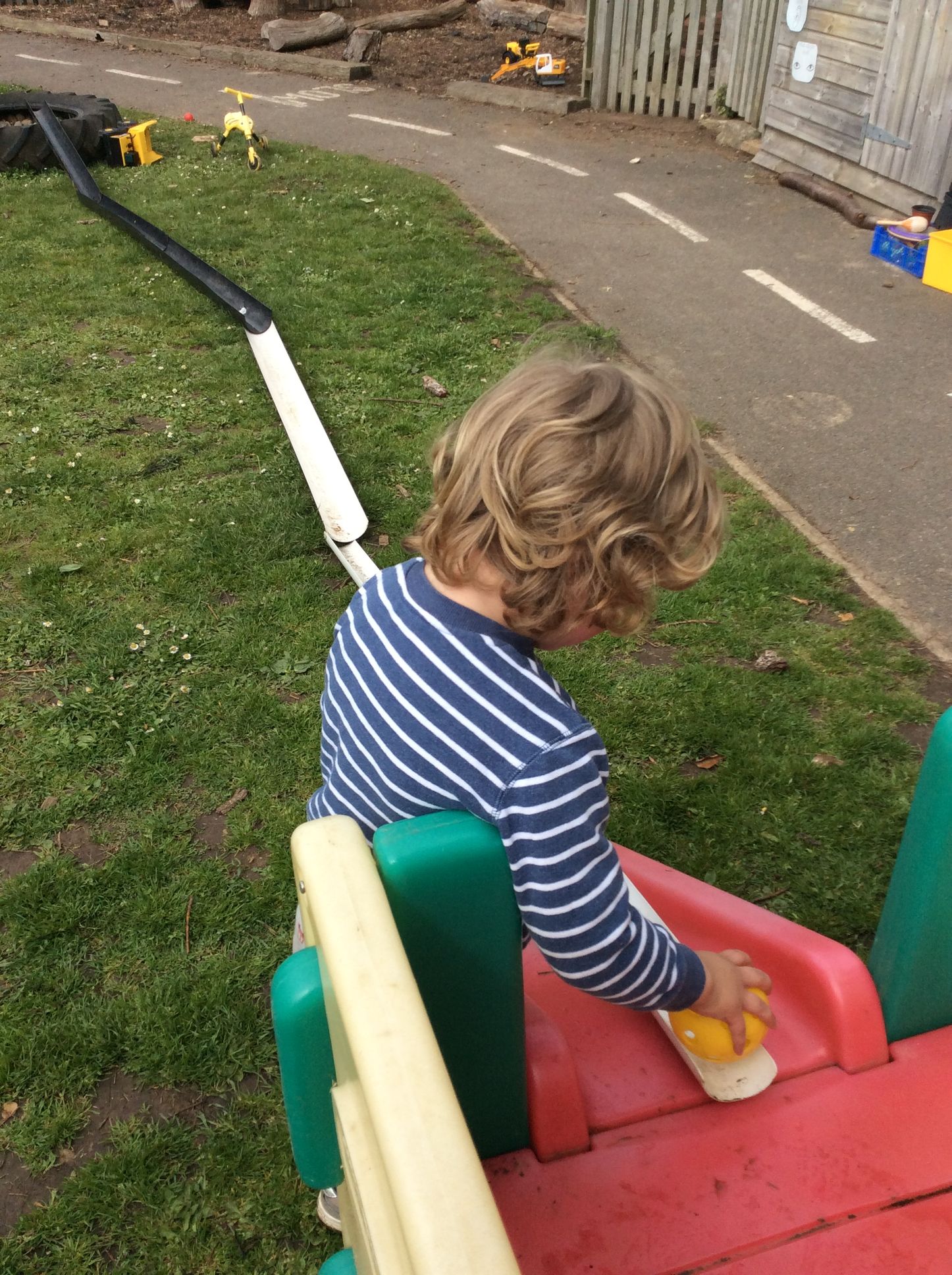 A young boy is playing on a slide in a playground.