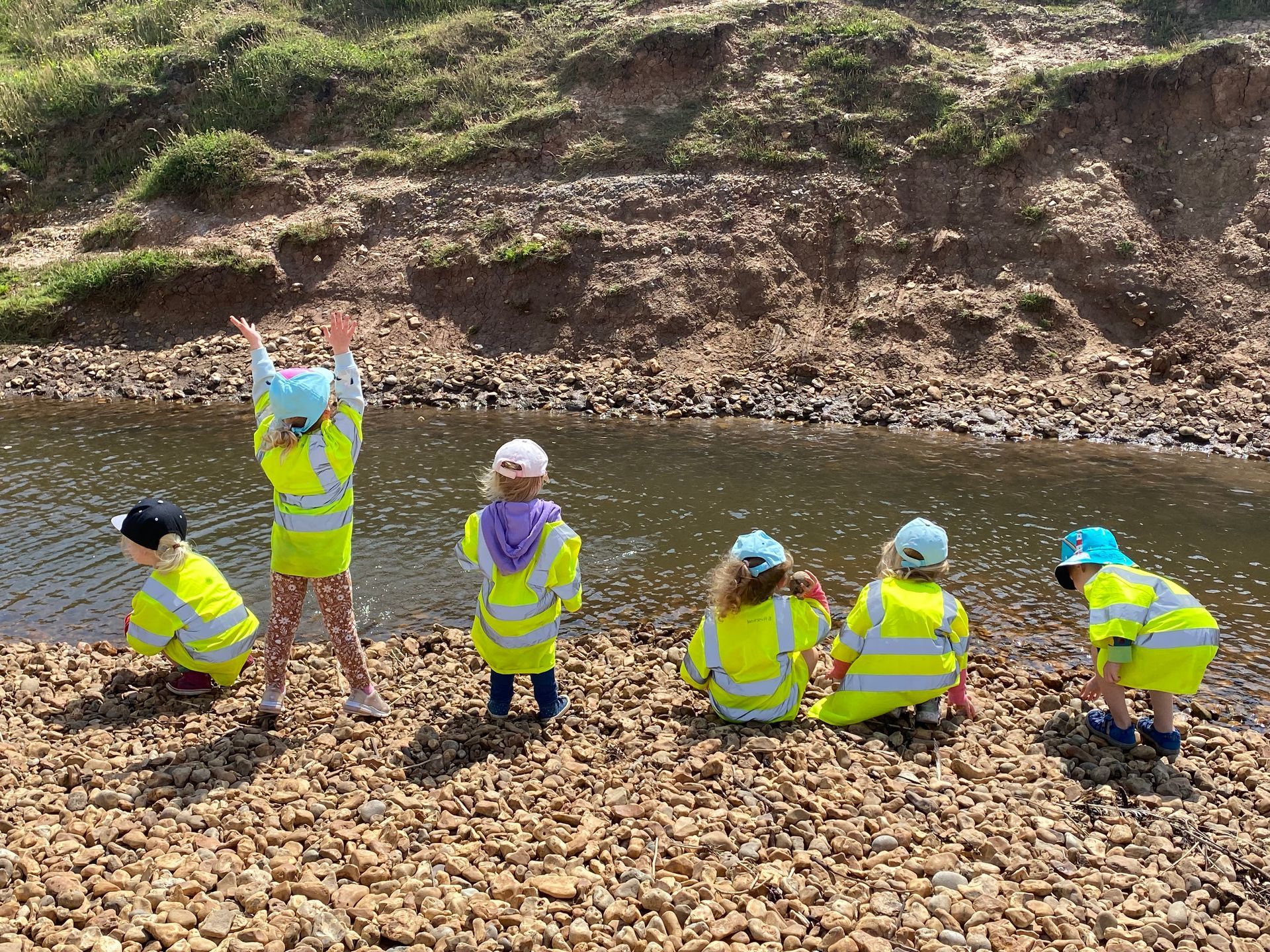 A group of children are playing by a river.