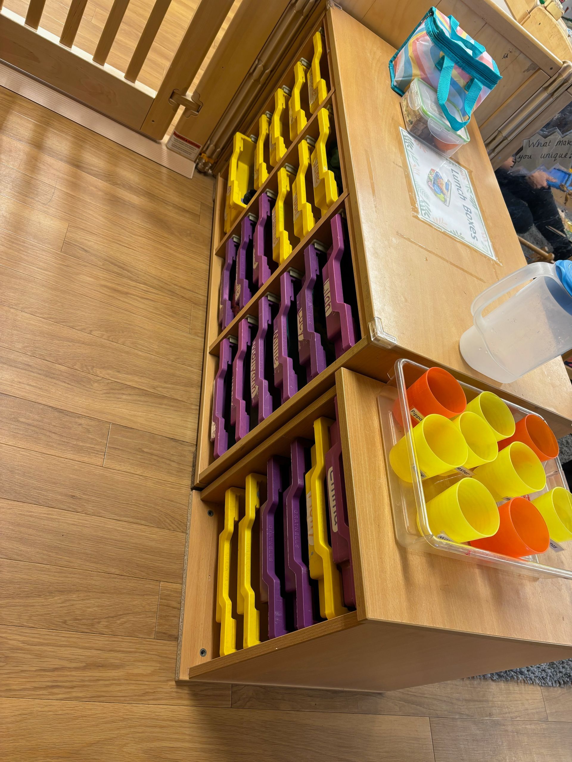 A wooden shelf with purple and yellow crayons on it