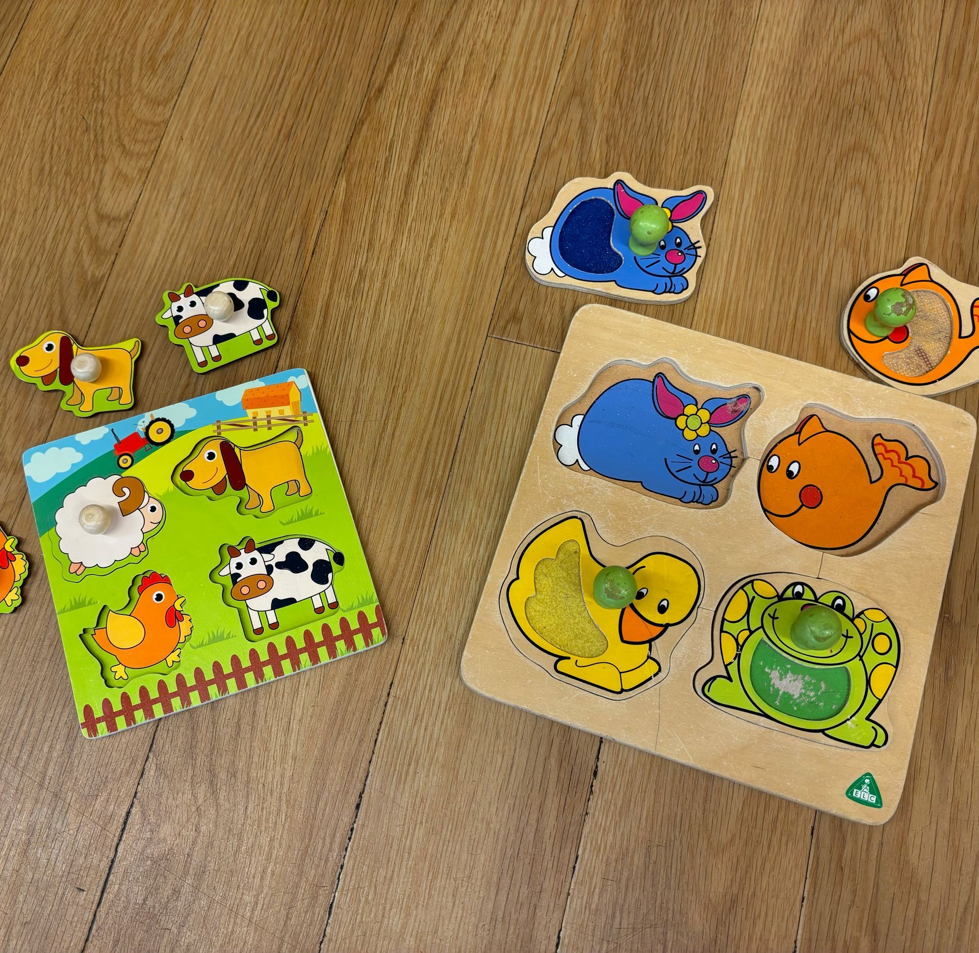 A wooden puzzle with animals on it is on a wooden floor