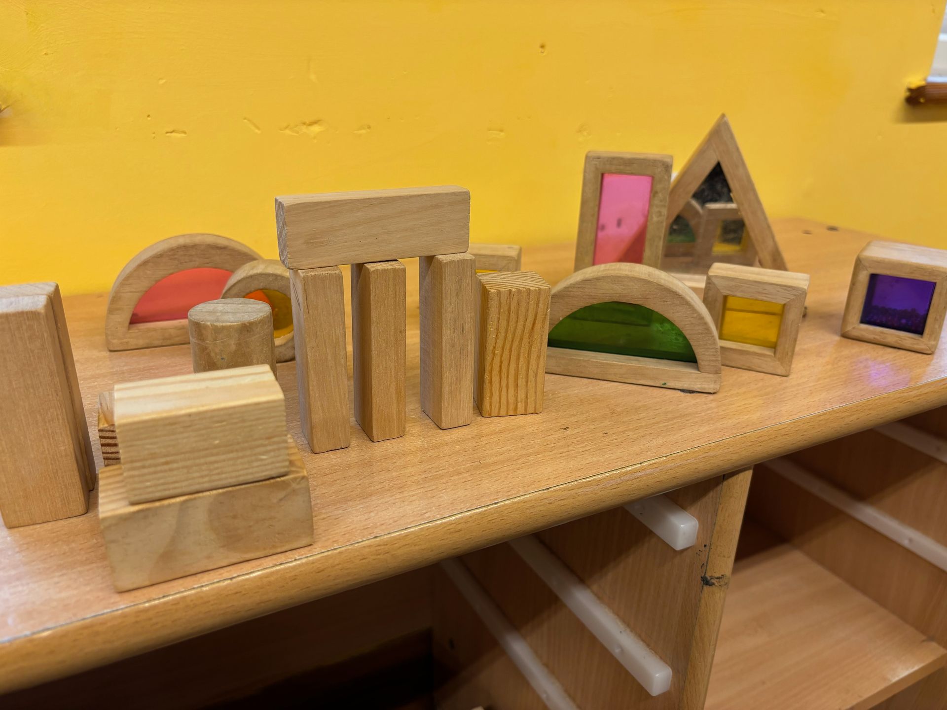 A bunch of wooden blocks are sitting on a wooden table.