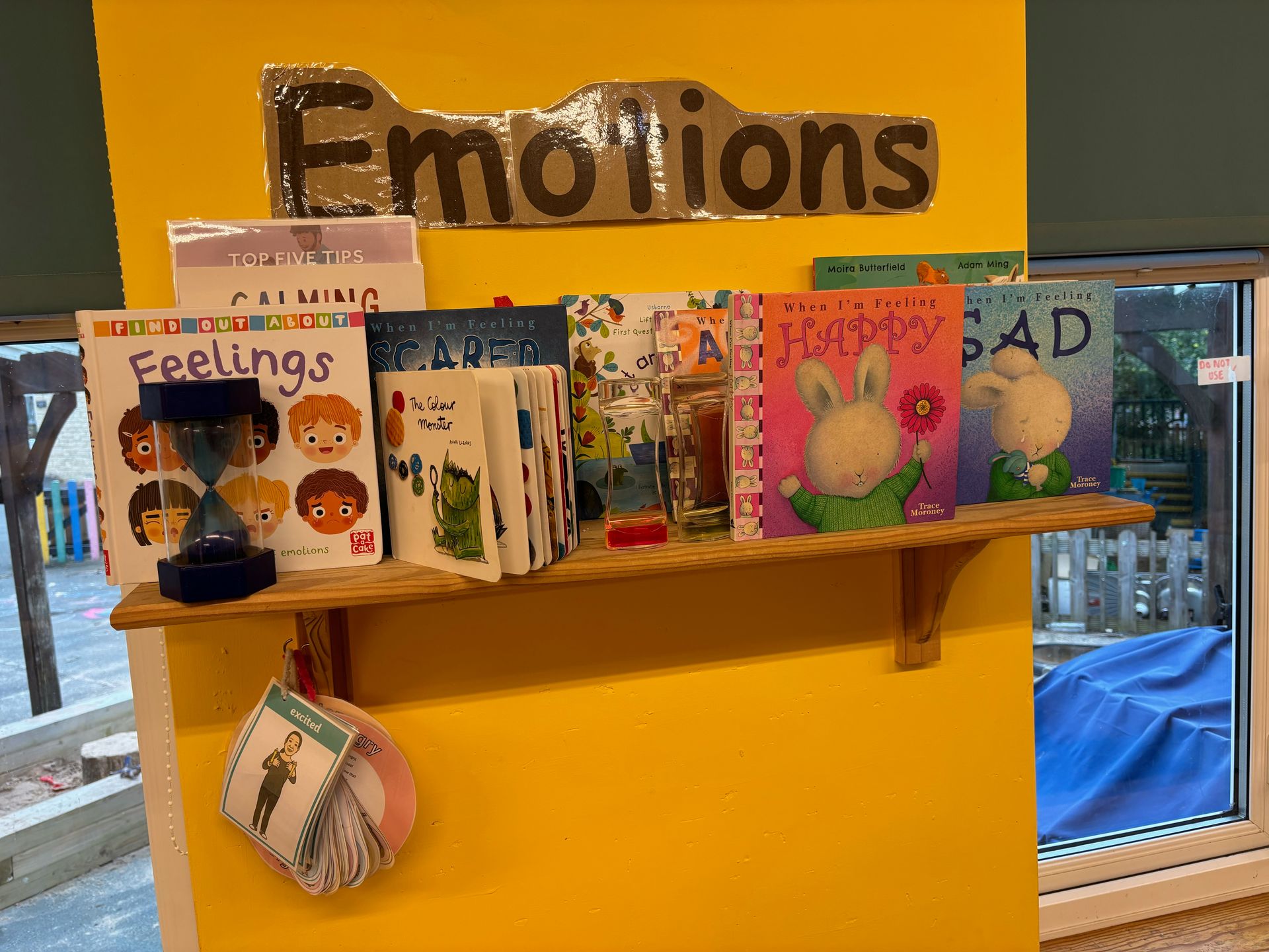 A shelf with books on it and a sign that says emotions