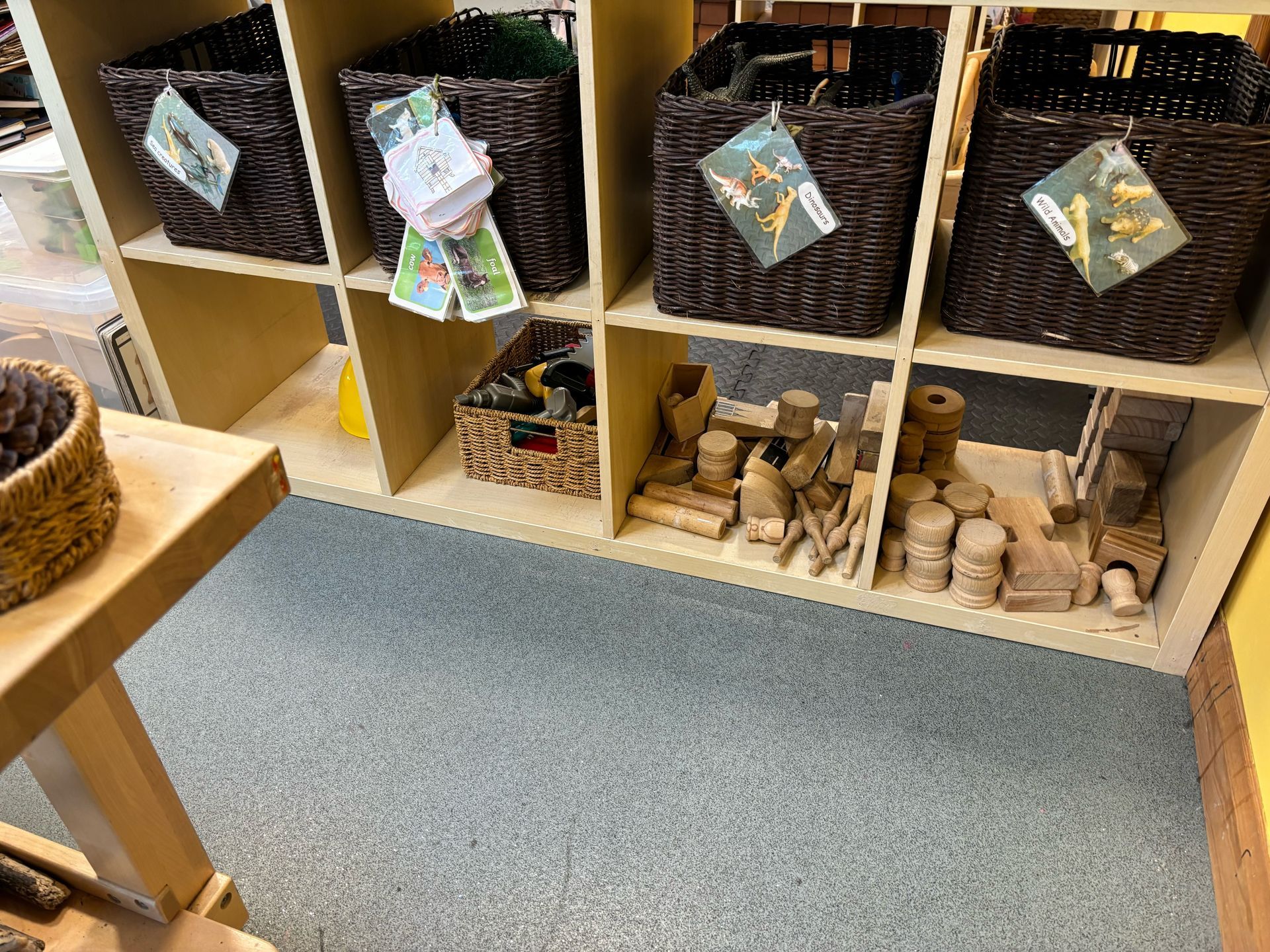 A shelf filled with wicker baskets and wooden blocks.