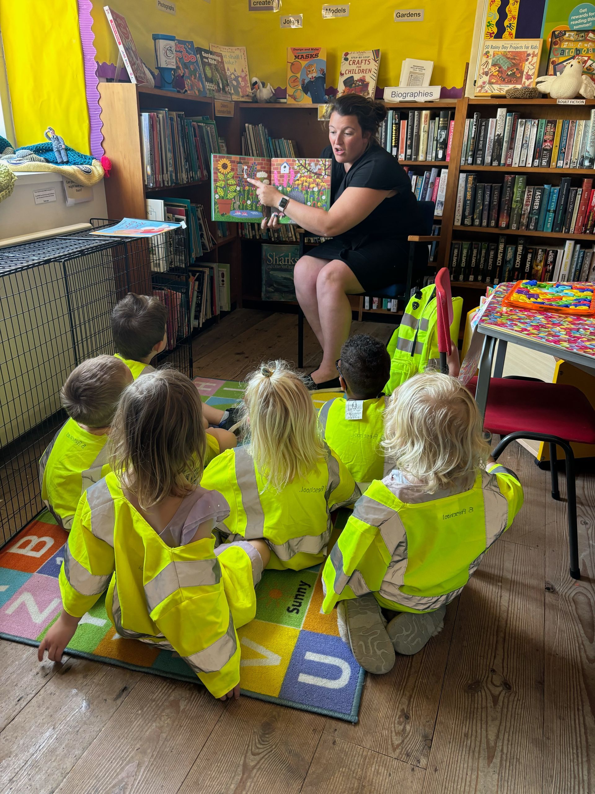 A woman is reading a book to a group of children.