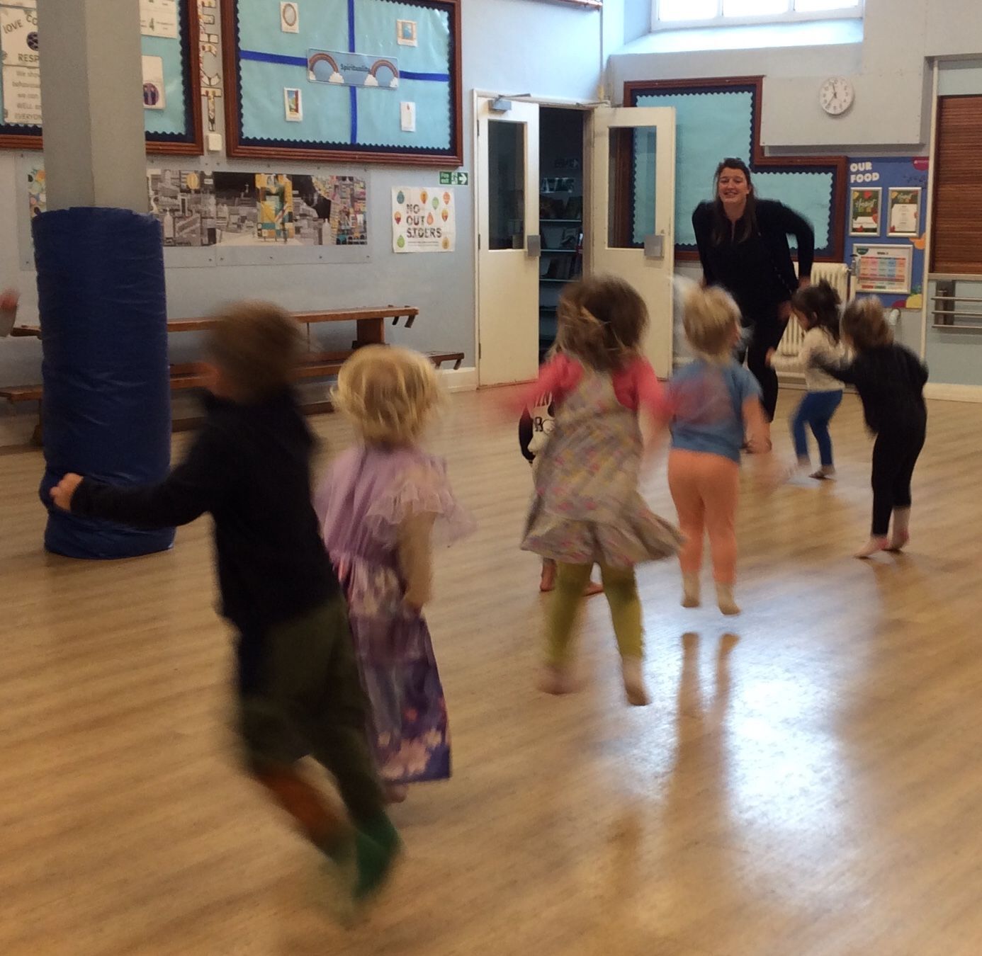 A group of children are playing in a room with a teacher
