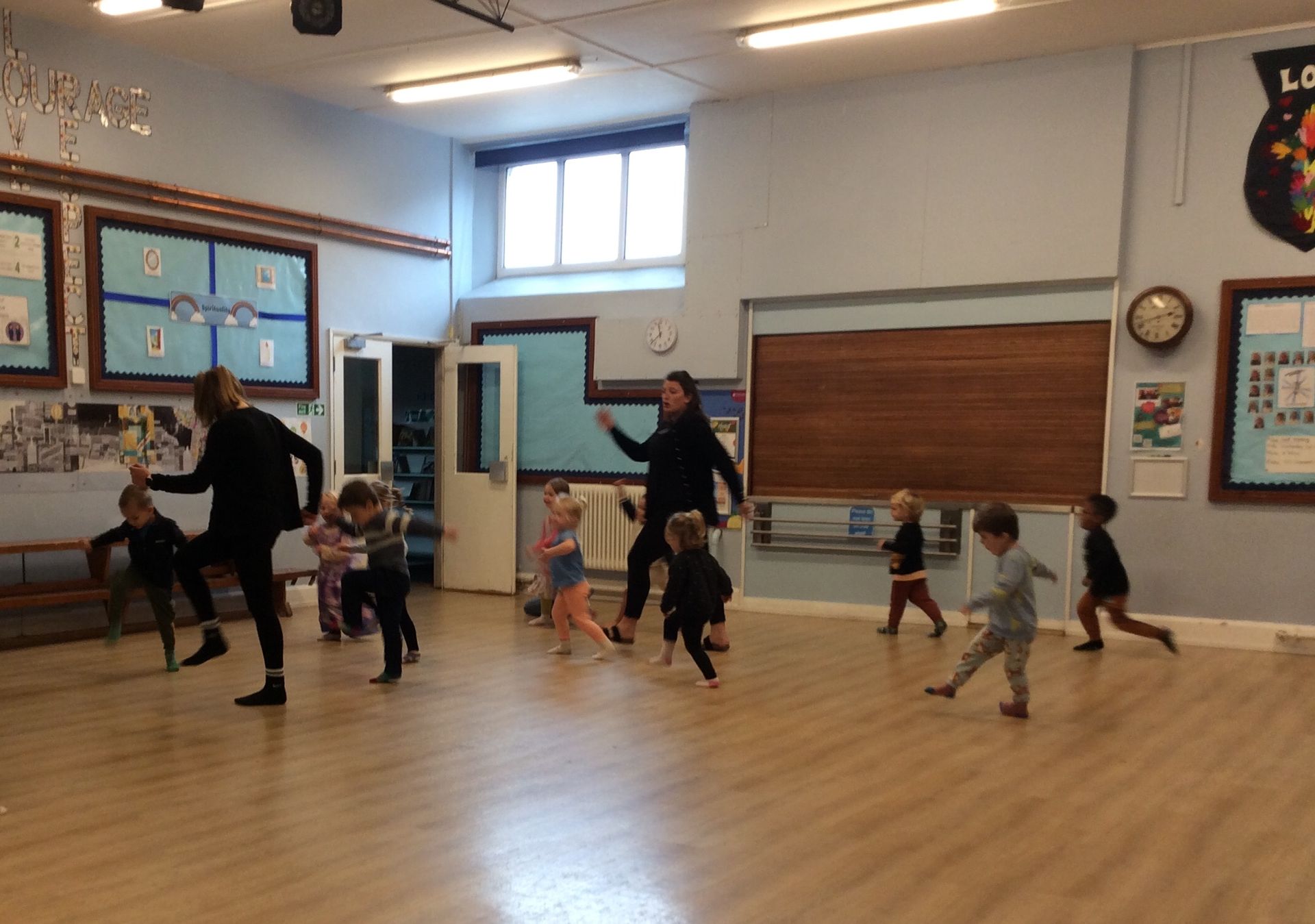 A group of children are dancing in a room.