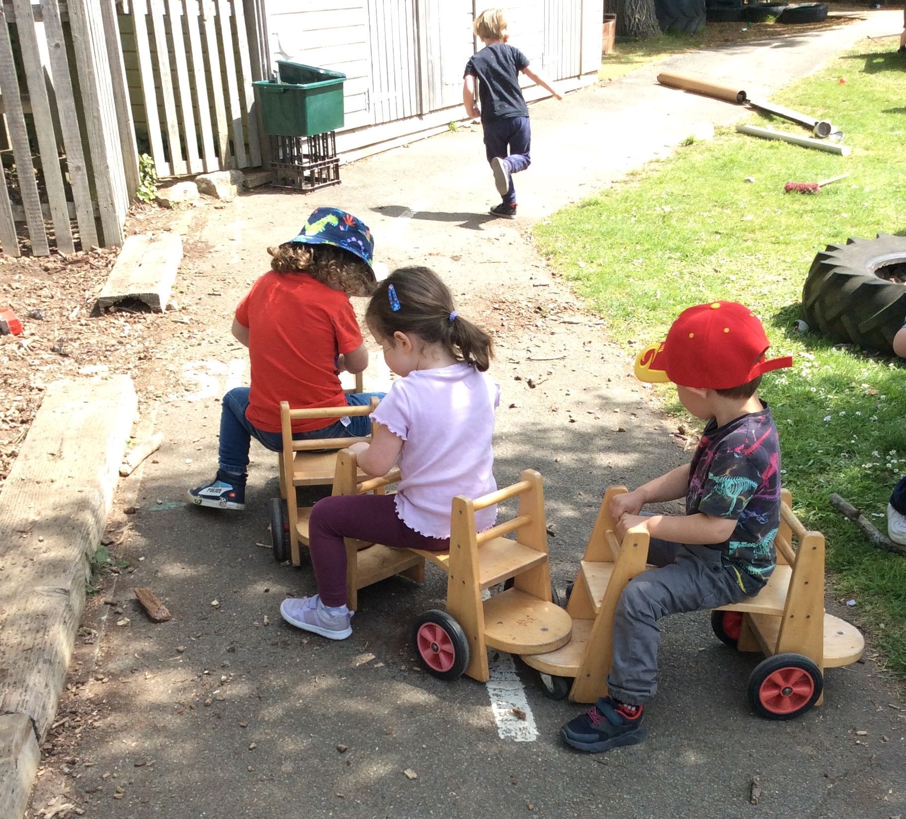 A group of children are playing with wooden toys on a sidewalk