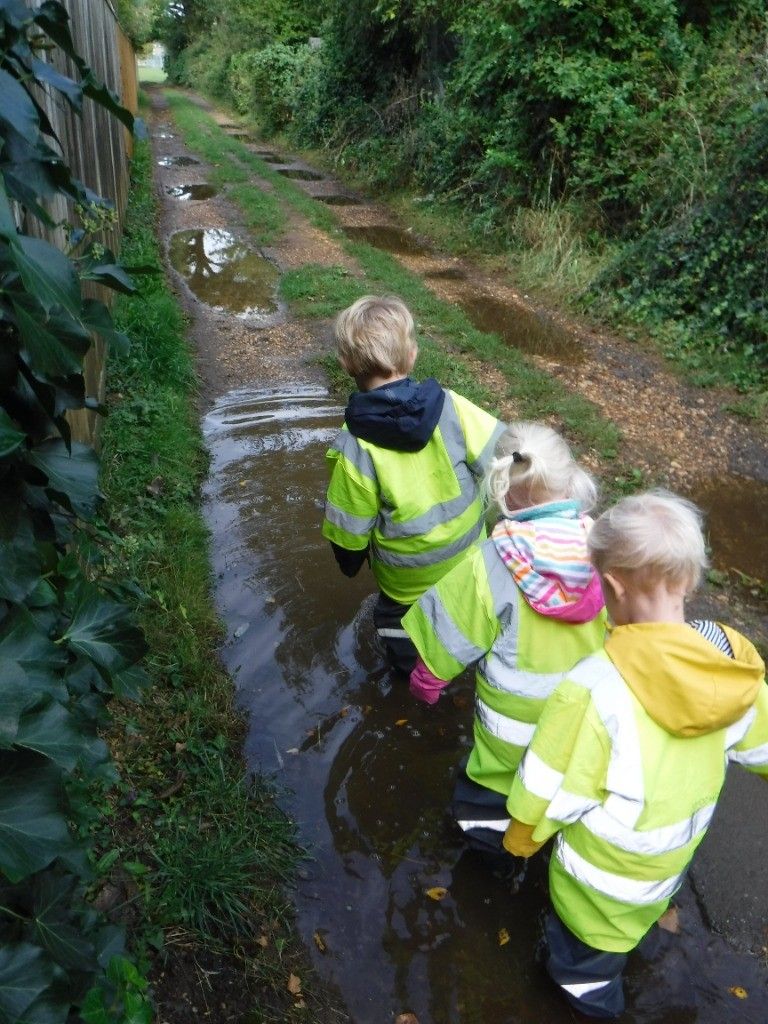 A group of children are walking down a muddy path.