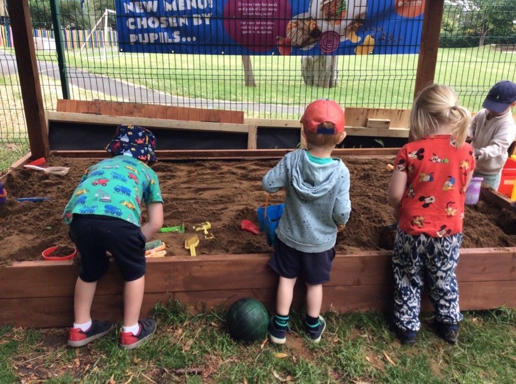 A group of children are playing in a sandbox.