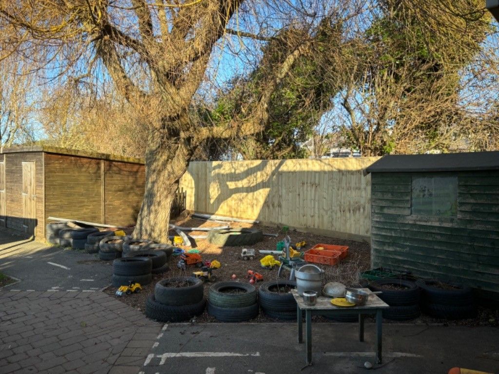 A backyard filled with tires , a table , and a shed.
