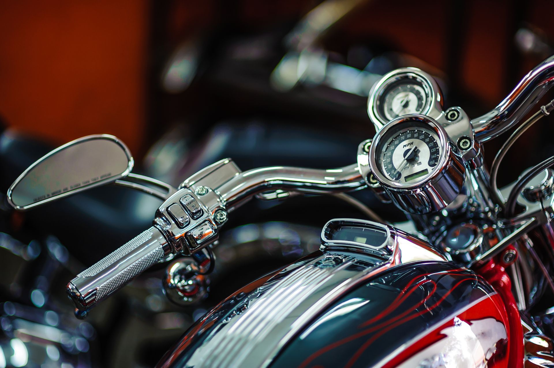 Close-up of a red motorcycle’s chrome handlebars and gauges
