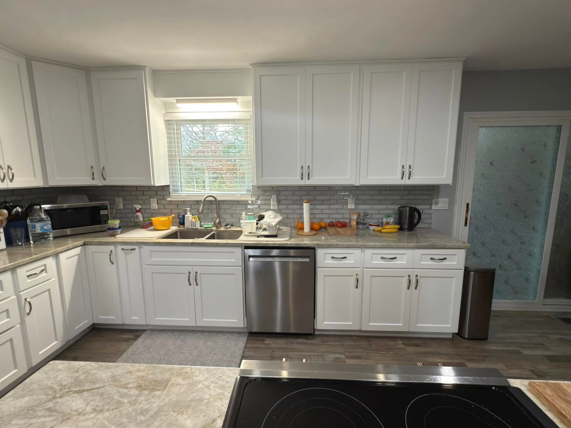 A kitchen with white cabinets and stainless steel appliances.