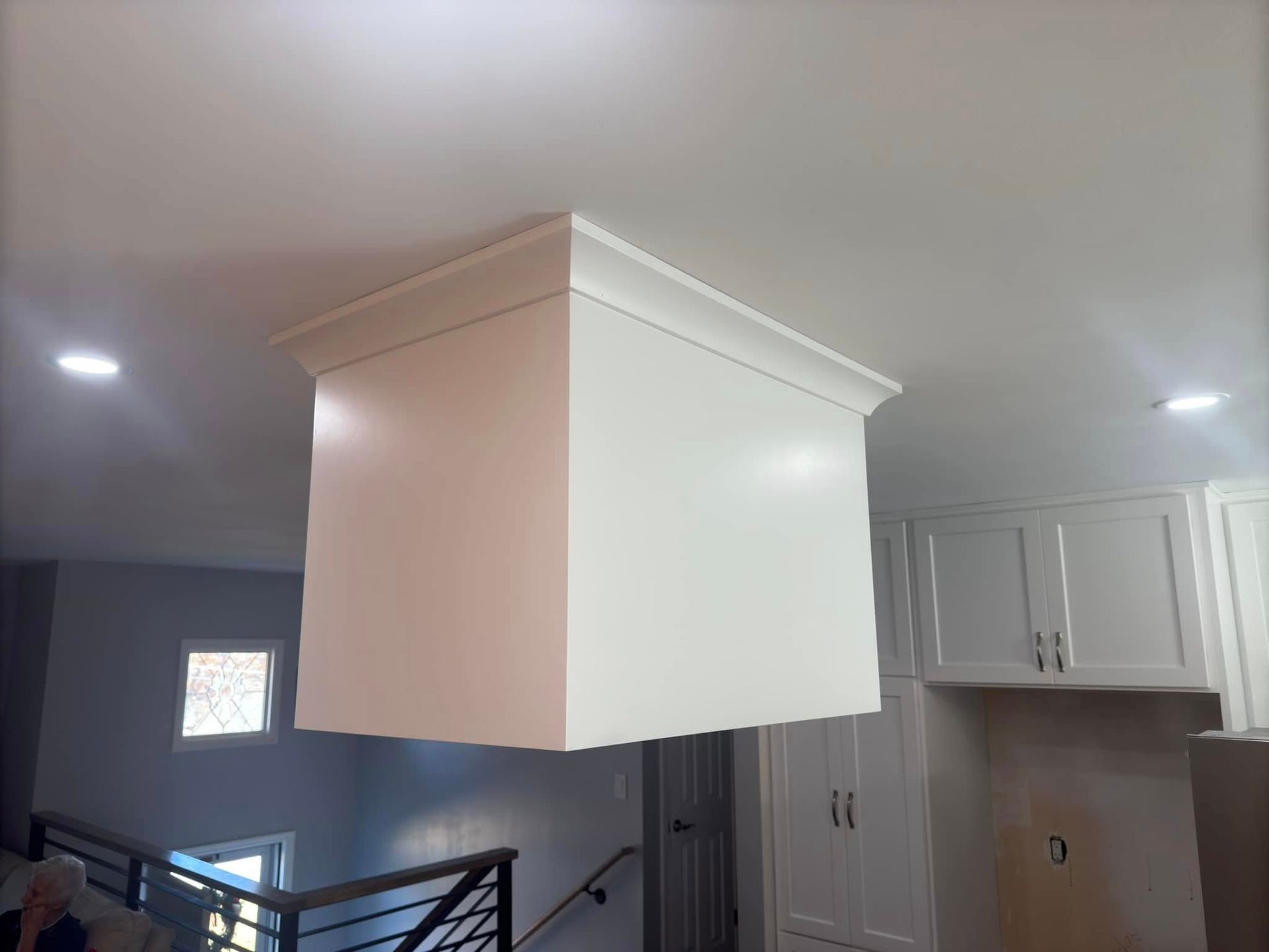 A white box is hanging from the ceiling in a kitchen.