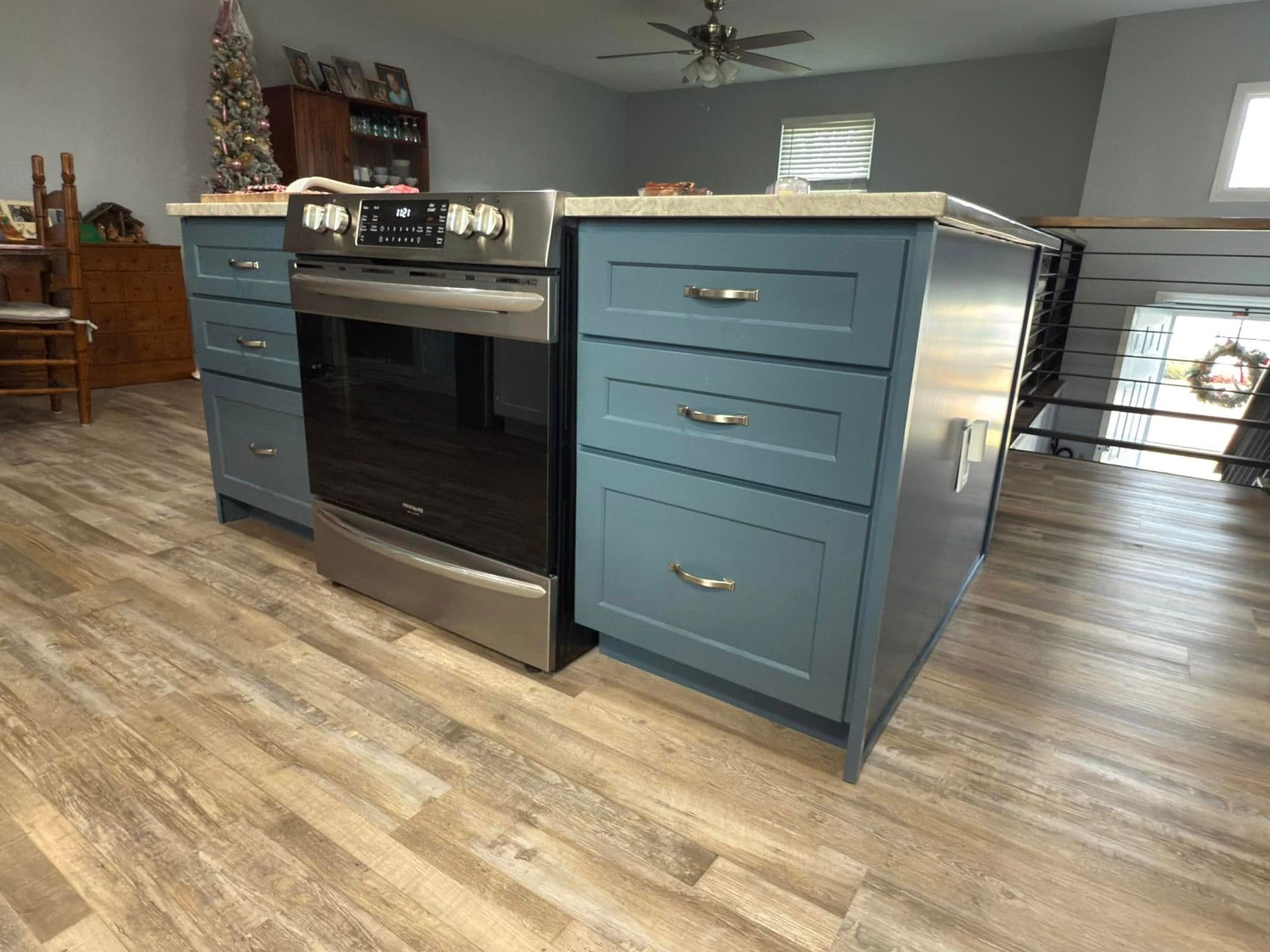 A kitchen with blue cabinets and a stove and oven.
