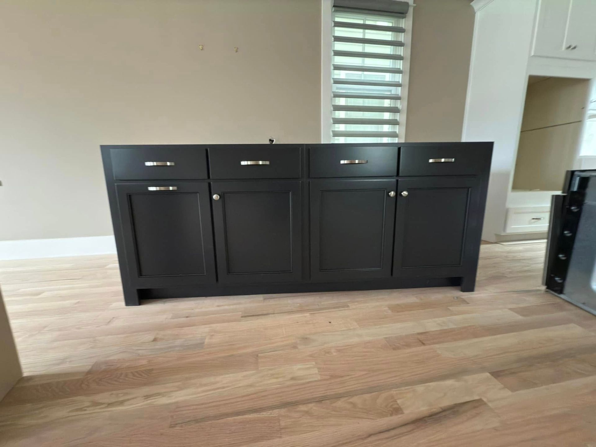 A black cabinet is sitting on a wooden floor in a room