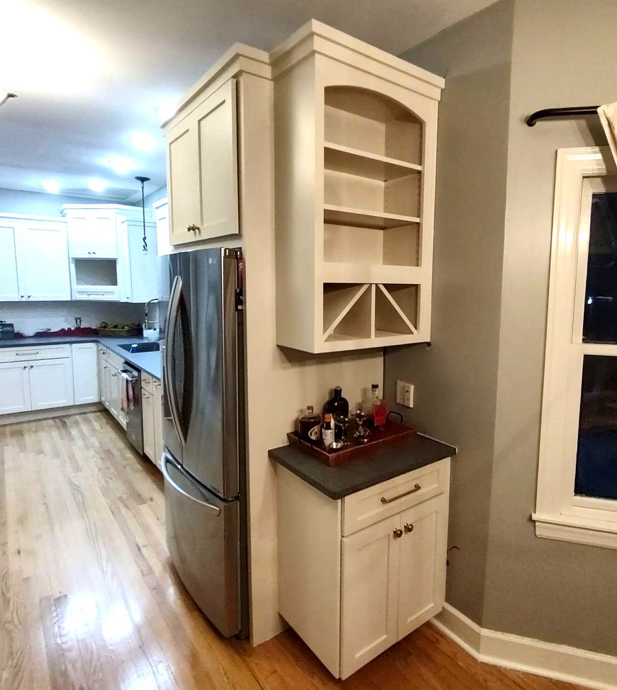 A kitchen with white cabinets and a stainless steel refrigerator