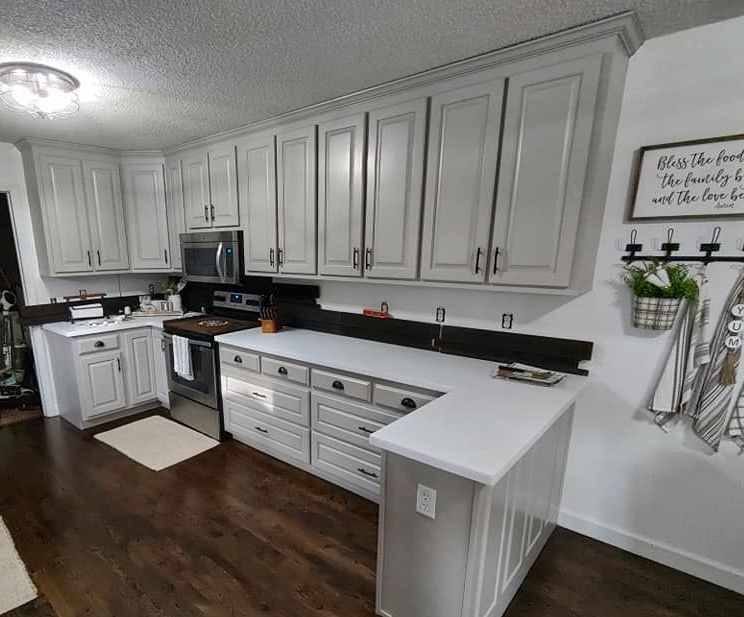A kitchen with white cabinets and stainless steel appliances.