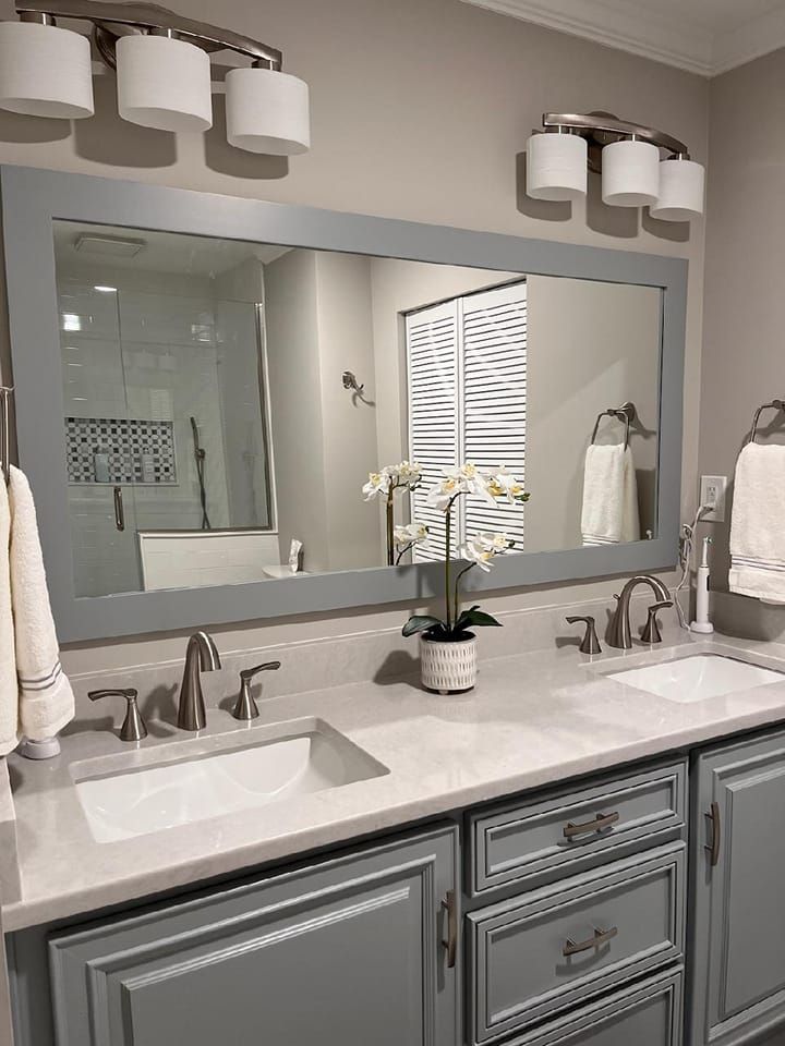A bathroom with two sinks and a large mirror.