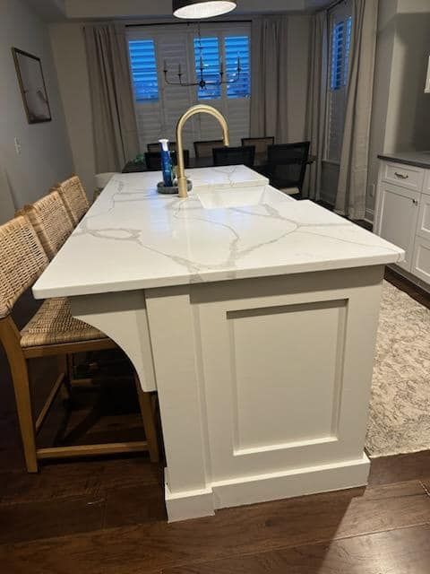 A kitchen with a large island and a sink.