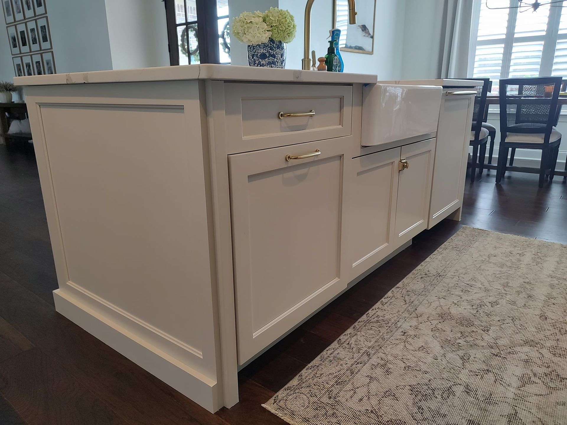 A kitchen island with a sink and a rug on the floor.